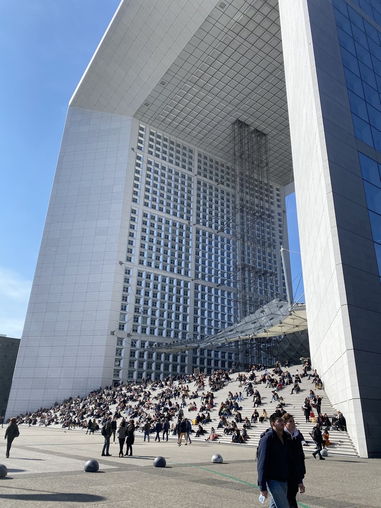 el arco de la défense y sus escaleras repletas de gente