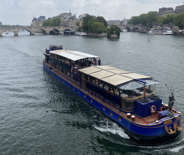 Barco con restaurante navegando por el Sena